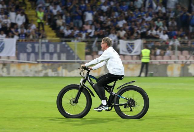 颇具喜感，因脚伤未愈奥地利主帅朗尼克只能骑电动自行车穿越球场